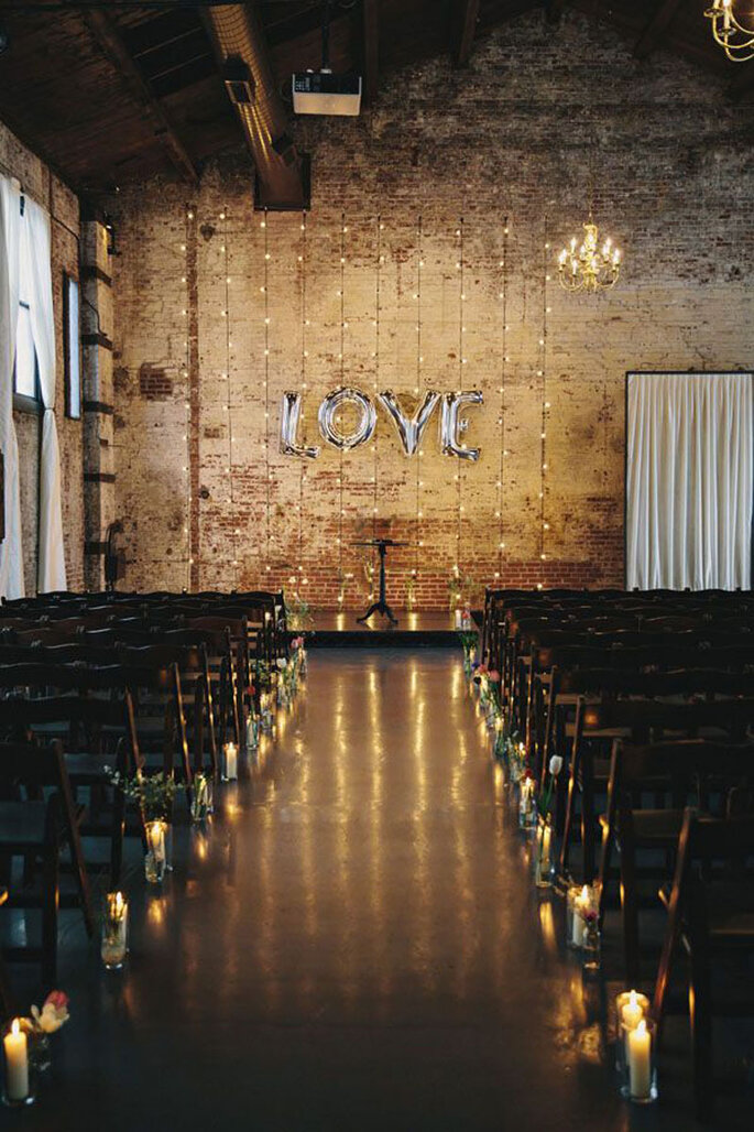 Cerimonia de casamento sem tapete, com velas e luzinhas. balão escrito Love ao fundo 