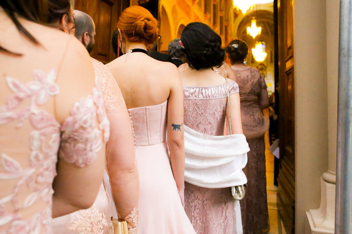 Madrinhas de casamento com vestido rosa entrando na igreja