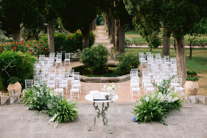 Allestimento cerimonia con rito civile, fiori e sedie in mezzo a giardino attorno ad una vasca