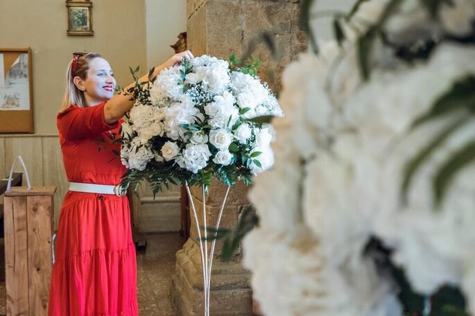 wedding planner, vestito rosso, sistema composizione di fiori bianca in vaso