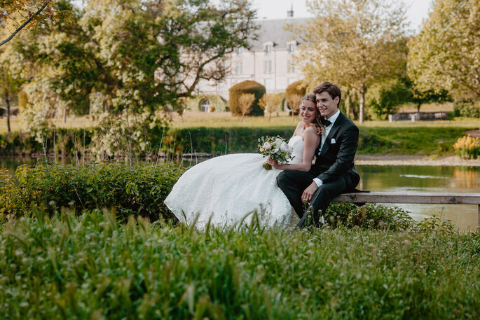 Deux mariés posent dans un jardin bucolique et champêtre 