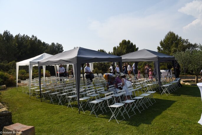 Installation de rangées de chaises blanches et de tentures en vue de la célébration d'une cérémonie laïque dans le parc des Salons du Mirapier 