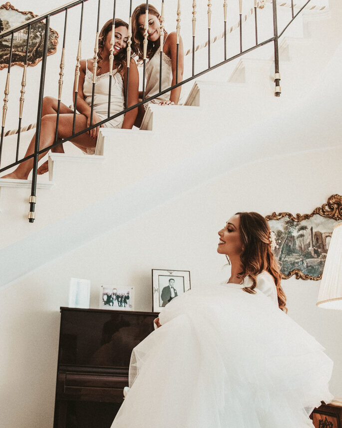 Fotomoderna Grillo, sposa con damigelle che la osservano dall'alto delle scale