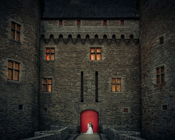 Photo de deux mariés devant leur Château de mariage 