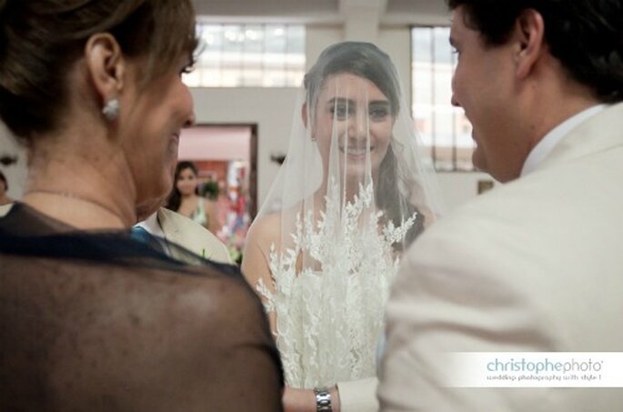 La novia aun con su velo sobre el rostro, alegre por el momento más especial de su vida. Foto: christopheweddingphoto.com