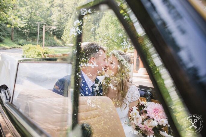 sposi in macchina che si baciano