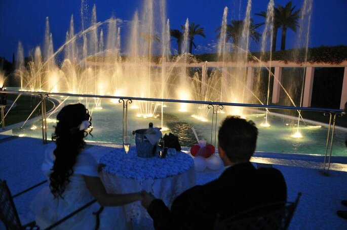 sposi osservano i giochi d'acqua e luci delle fontane