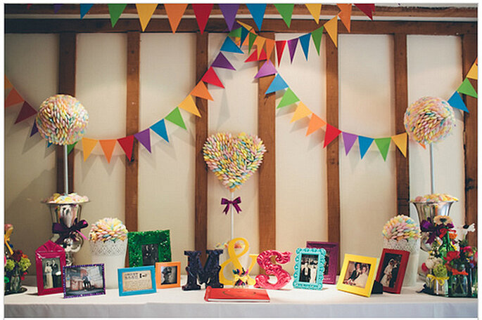 Mesa de dulces con las iniciales de los novios, banderines y portarretratos. Foto: We Heart Pictures