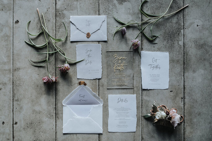 Verschiedene Elemente der Hochzeitspapeterie von Bonjour Paper mit Menü, Einladung und Save the Date-Karte, organisiert von Freakin' Fine Weddings.