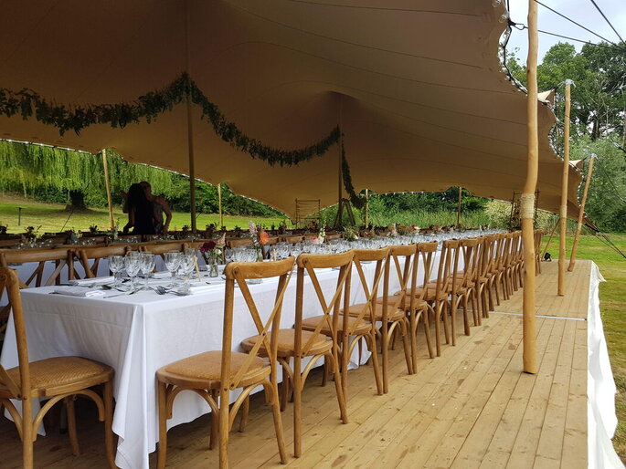 Restaurant pour un mariage champêtre ou bohème avec de grandes tables et chaises en bois 