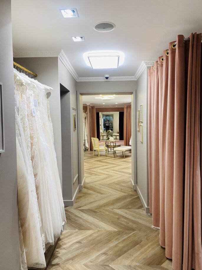 showroom de mariage avec un rideau rose en velour, du parquet et des murs taupe 