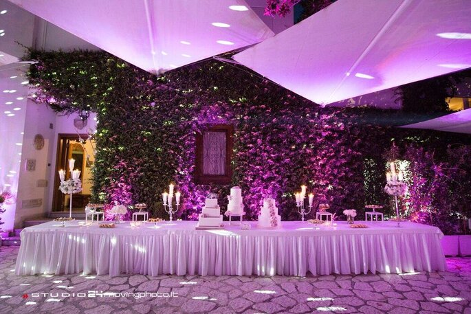 Villa Mazzarella, parete con vite, tavolata allestita per buffet dolci, wedding cake, luci viola