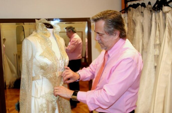 Petro Valverde coloca un abrigo de encaje a uno de sus diseños de novia