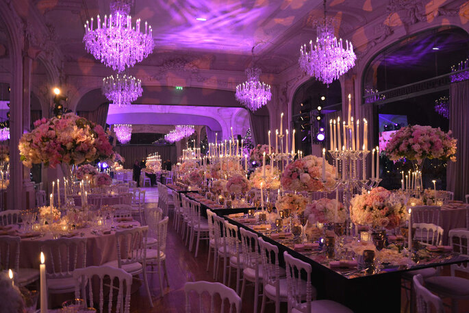 Salle de réception pour mariage illuminée de bougies et des chandeliers