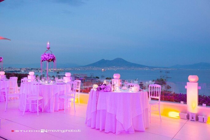 Villa Mazzarella, allestimento tavoli con luci viola su terrazza, sfondo Golfo