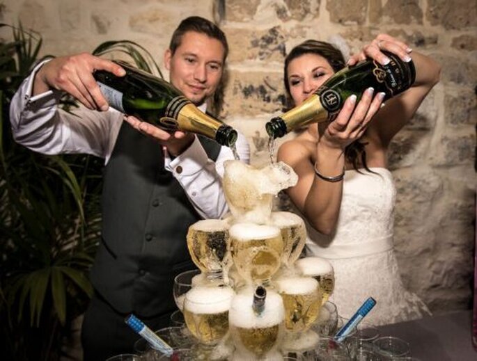 les mariés versent le Champagne sur la pyramide de coupes