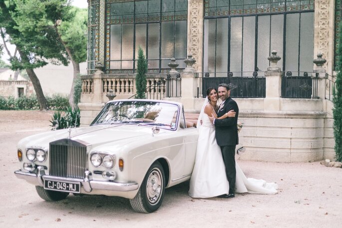 Deux mariés avec une voiture de collection devant la façade du Château de Beaumetane