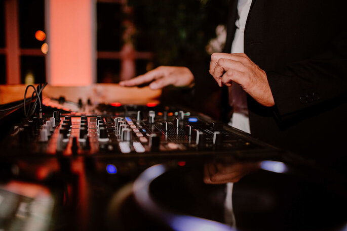 Un DJ en train de mixer pendant une soirée de mariage