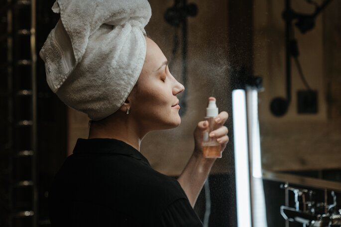 Kobieta używająca utrwalacza makijażu w spray'u