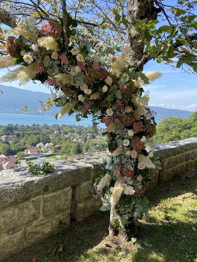 Décoration florale majestueuse dans un arbre pour un mariage avec vue sur un lac