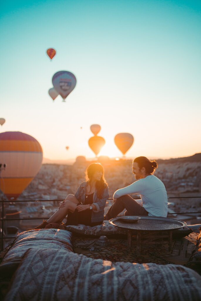 Para siedząca w otoczeniu latających balonów 