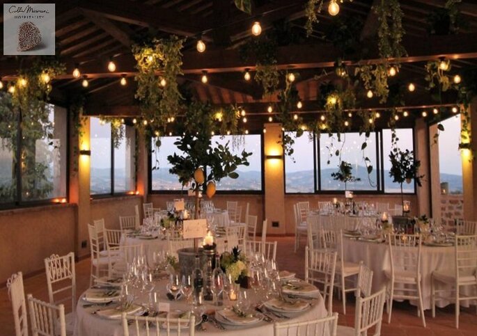 Une salle de restaurant décorée pour un mariage, avec une superbe vue sur la campagne toscane