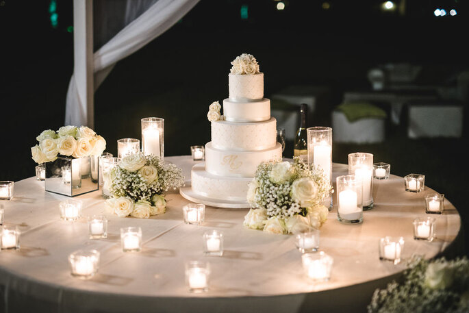 torta nuziale, fiori e candele, toni del bianco