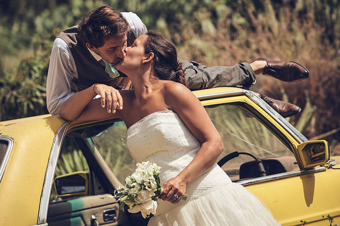 Photo de deux mariés sur une voiture jaune - David Coppieters