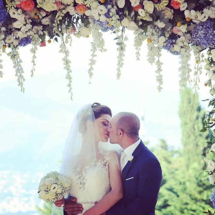 sposi sotto un arco di fiori