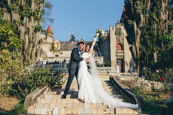 Recién casados posando en un castillo como escenario
