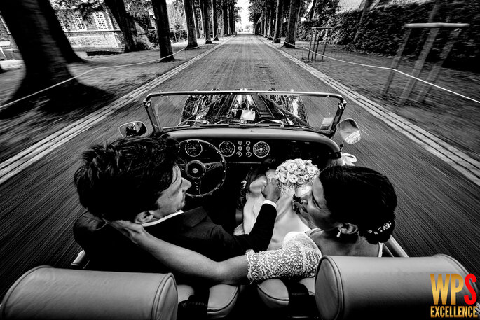 Couple de mariés à bord d'une voiture rétro, photo primée