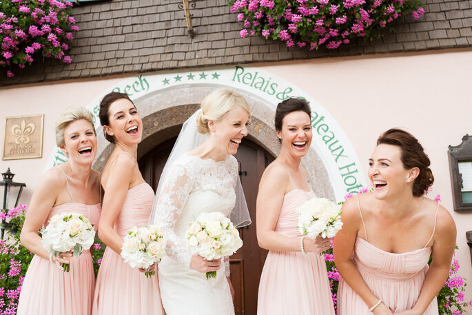 Noiva e madrinhas em cor de rosa dando risada