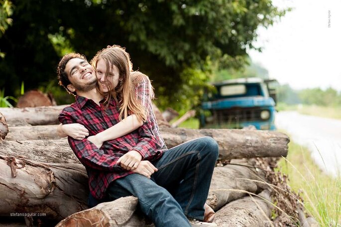 Casal abraçado em frente a uma caminhonete azul