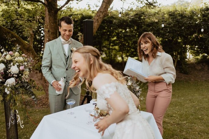 Wortschwärmerin Hannah lacht herzlich mit einem Brautpaar
