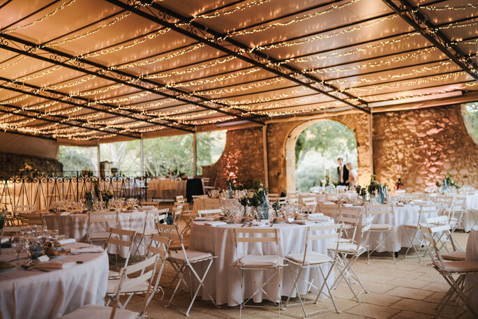 une salle de réception de mariage en bois avec des tables blanches