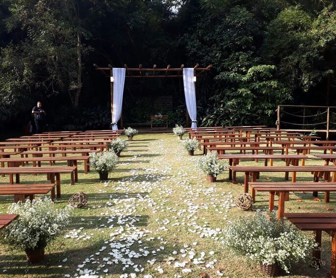 Cerimonia de casamento com pétalas de flores no caminho.