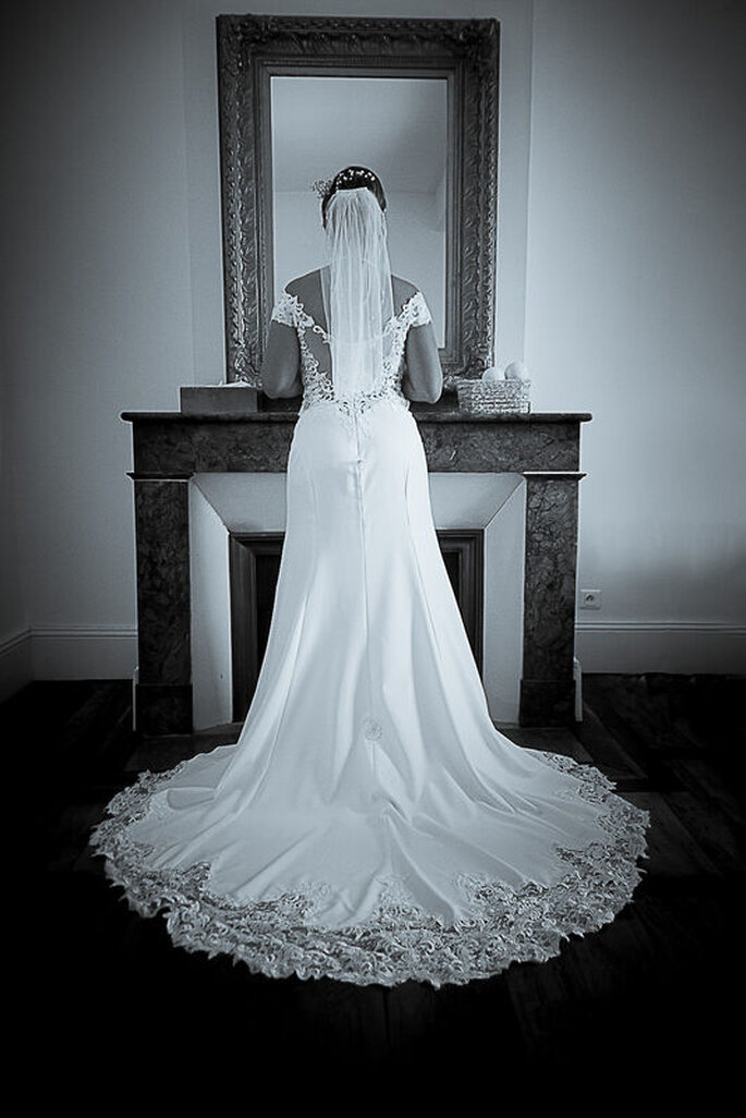 La mariée à la fin de ses préparatifs vêtue d'une superbe robe en dentelles