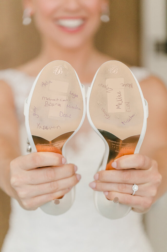 sapatos de noiva com assinaturas na sola noiva ao fundo