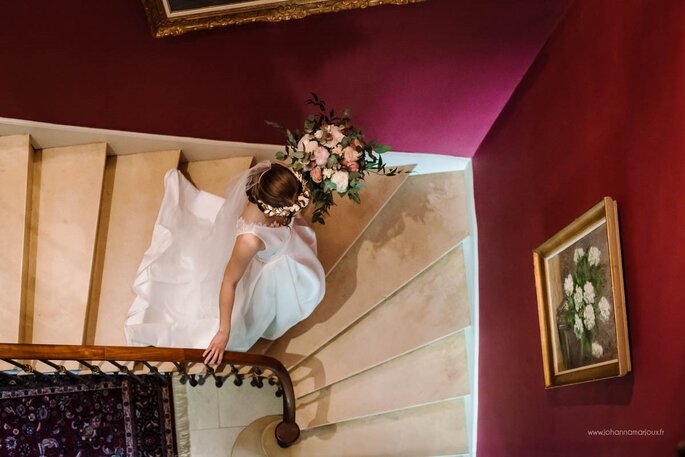 une mariée dans les marches d'escalier d'un château 