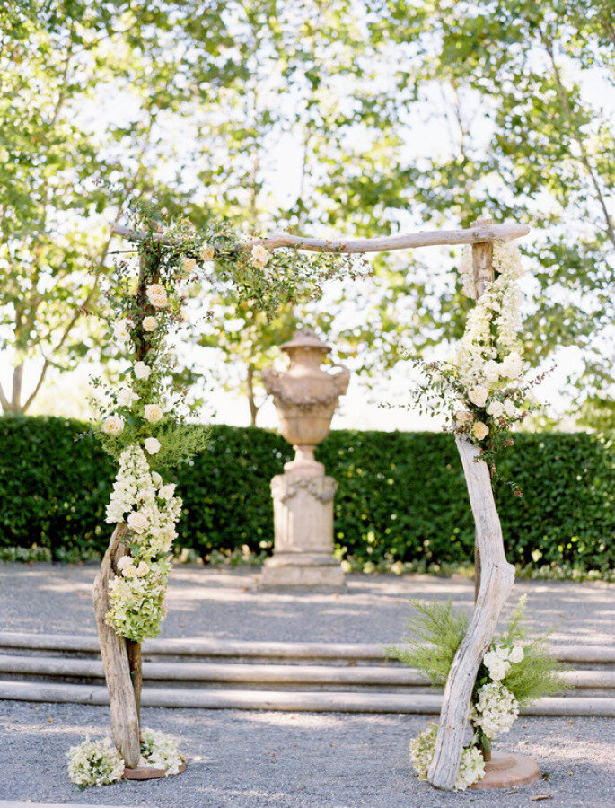 altar de boda estilo rustico con troncos y flores blancas para ceremonia al aire libre