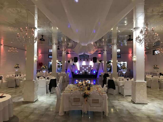 Tables blanches dressées avec centre de table fleuri pour un mariage au Patio d'Emmanuel