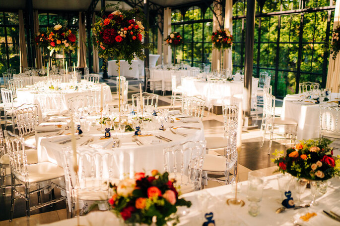 une salle de mariage avec des centres de tables fleuris - Marjorie Mariages & Réceptions