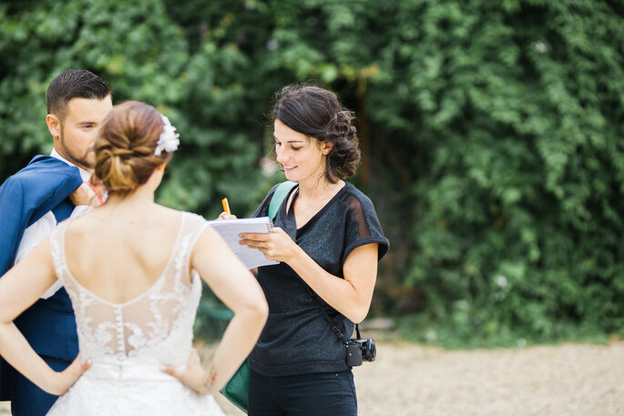 Léonie le jour d'un mariage, prenant des notes auprès des invités. 
