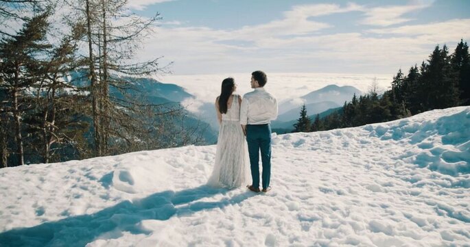 les mariés posent devant la montagne enneigée