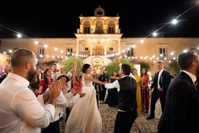 Coppia di neo sposi ballando all'esterno della location italiana