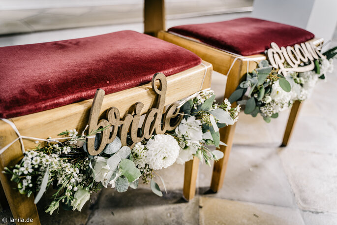 Stühle des Brautpaares zur Trauung mit Aufschrift "bride" und "groom"