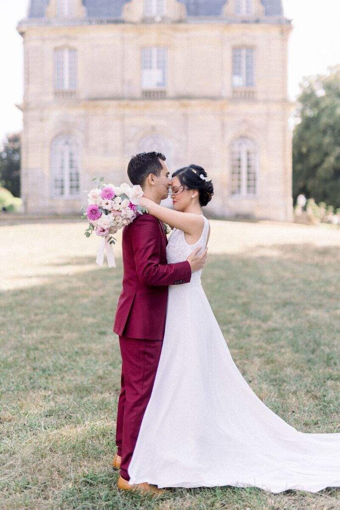 le marié embrasse la mariée sur le front devant le Château de Champlâtreux 