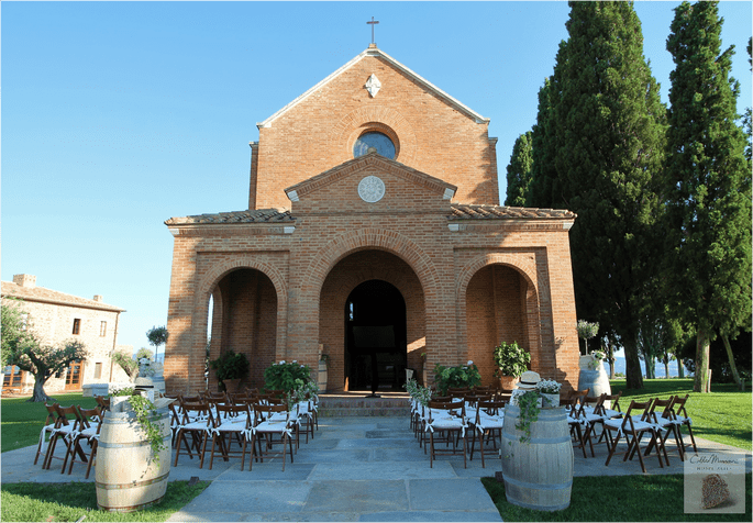 Des chaises disposées pour une cérémonie laïque en extérieur devant la façade d'une église