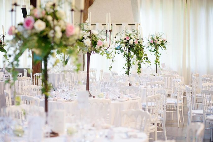Tables blanches avec des centres de tables à fleurs 