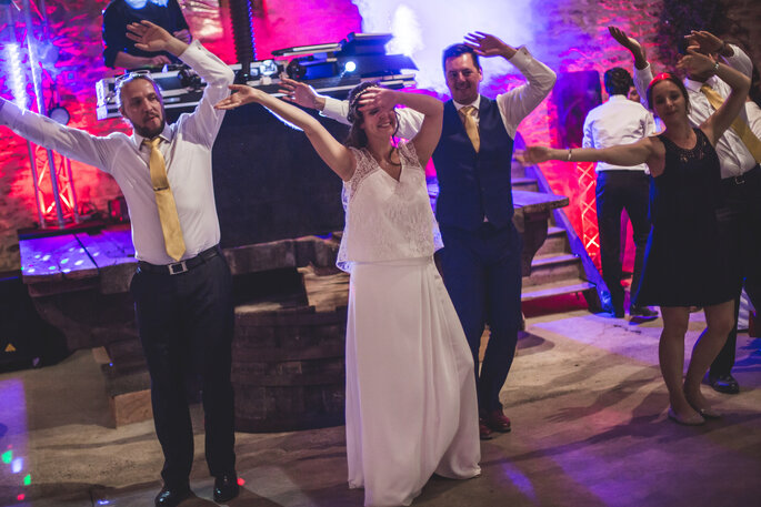 Un couple de mariés et leurs proches en train de danser pendant la soirée du mariage